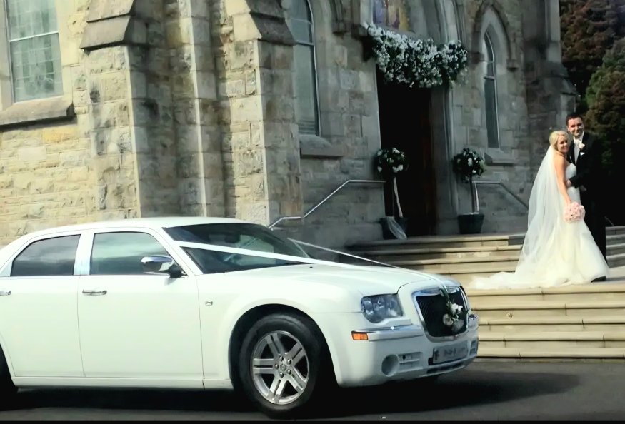 Glamorous Dressed Bride and Groom leaving Church into Beautiful white Bentley 